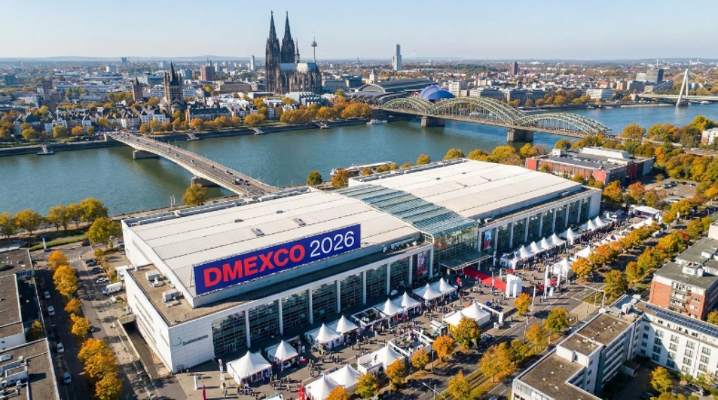 Aerial view of Koelnmesse exhibition center in Cologne, Germany, the venue for DMEXCO 2026, with the Rhine River and Cologne Cathedral visible in the background