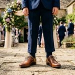 Young boy wearing polished brown leather oxford shoes standing outside a wedding venue