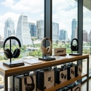 A traveler wearing wireless Bose headphones while relaxing at a sunny outdoor cafe.