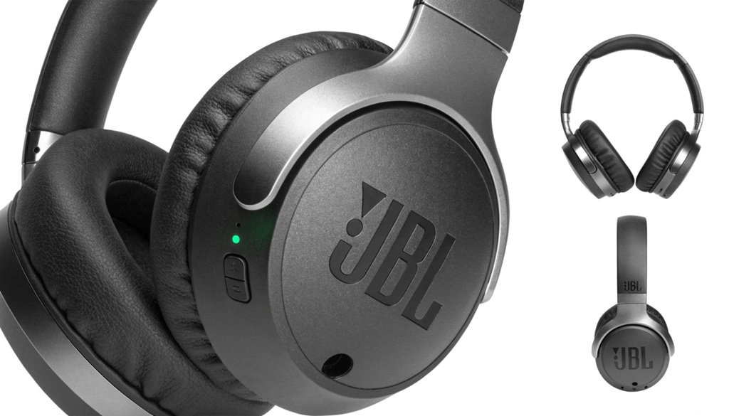 Black JBL wireless over ear headphones on a sleek desk surface.
