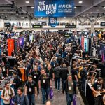 Crowded NAMM Show floor filled with music gear exhibitors and attendees at Anaheim Convention Center